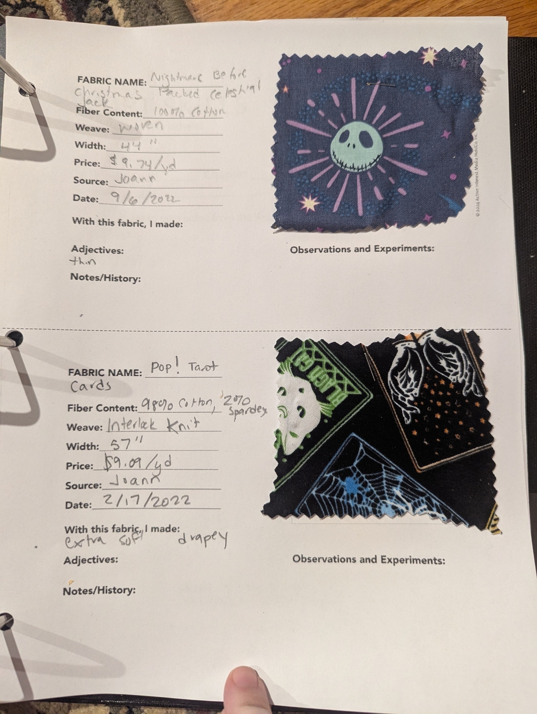 Auto-generated description: A scrapbook page features descriptions and swatches of two fabrics, one with a celestial pattern with Jack Skellington’s head and the other with tarot card designs.